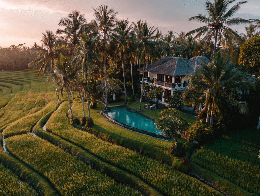 Luxury villa in Bali surrounded by rice fields and palm trees, symbolizing property ownership, investment, and tax compliance for foreigners.