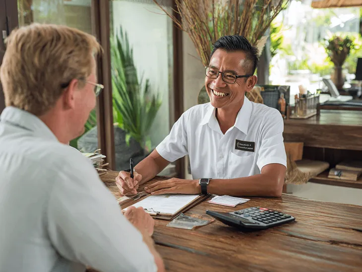 Accountant in Bali reviewing PT PMA financial reports for OECD compliance under PMK 136/2024, ensuring IIR and DMTT tax alignment in Coretax DJP Online.