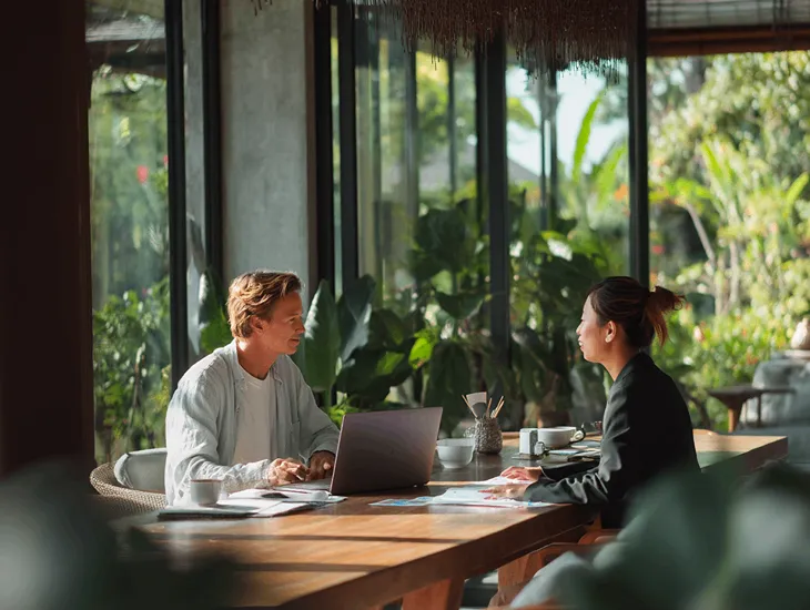 Foreign PT PMA owner in Bali reviewing digital sales invoices with tax consultant on Coretax DJP Online to ensure VAT accuracy and compliance