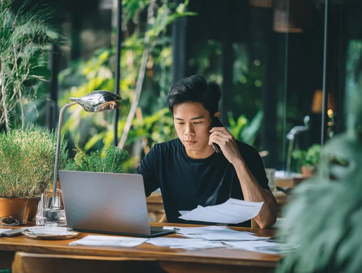 Foreign PT PMA owner in Bali verifying a suspicious tax call with consultant to report potential Directorate General of Taxes fraud and protect company compliance