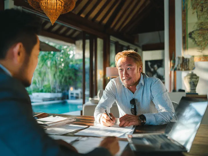 PT PMA owner in Bali reviewing tax records with a consultant to report intermediary payments and avoid penalties under Indonesian tax rules