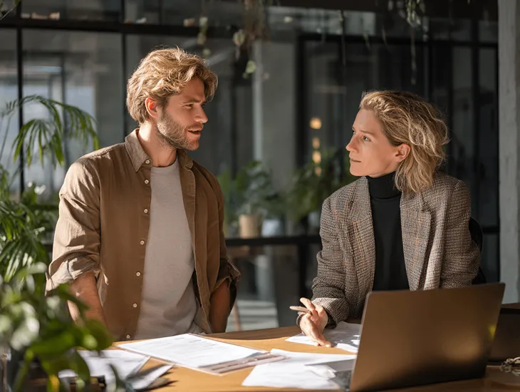 Business owner updating e-Faktur settings on laptop to reflect the 2.4% VAT regulation change.
